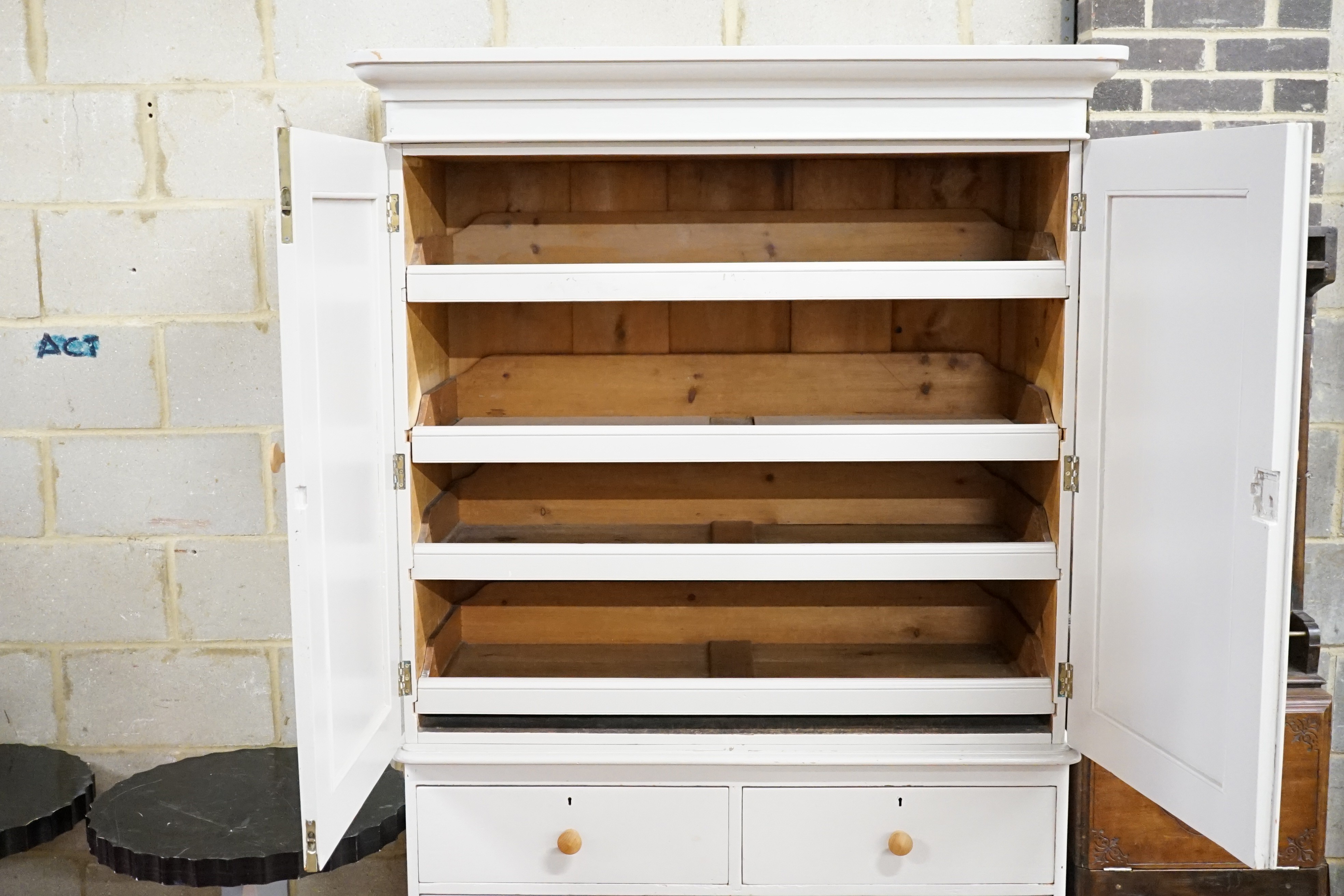 A Victorian later painted pine linen press, with two doors enclosing sliding trays, width 130cm, height 208cm